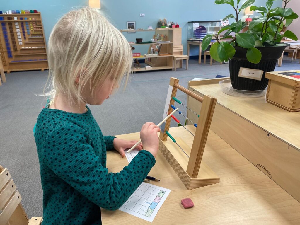 child working with abacus in a montessori classroom
