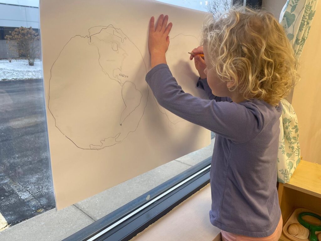 child making map of continents in a montessori classroom