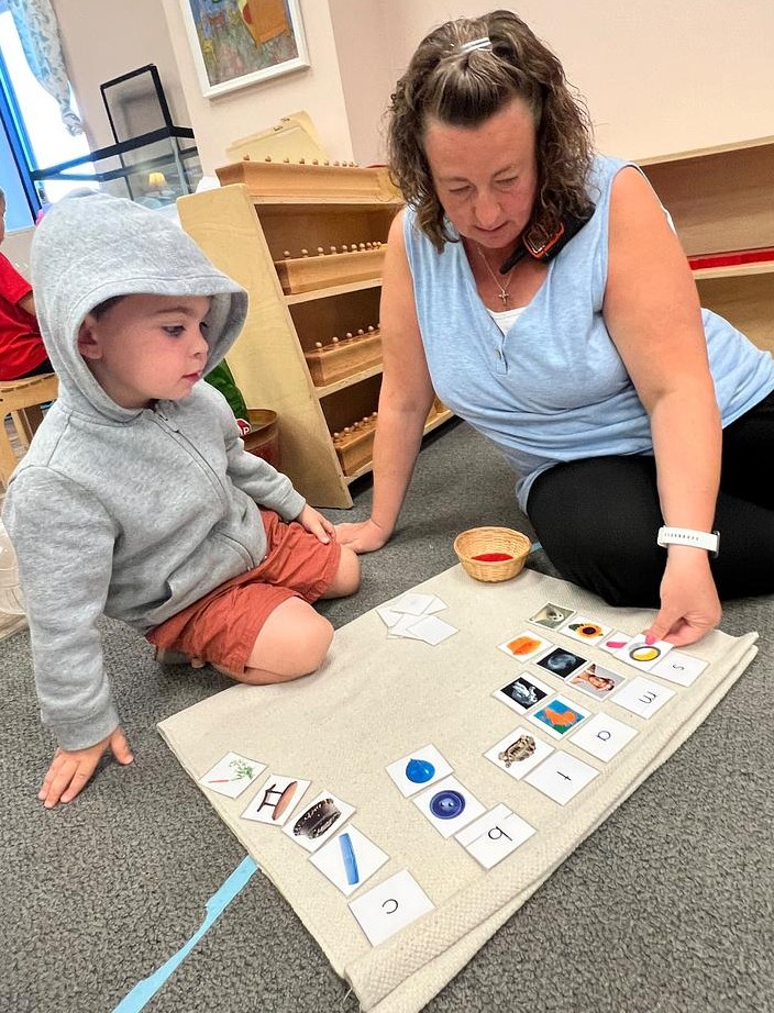 student working with guide in a montessori school