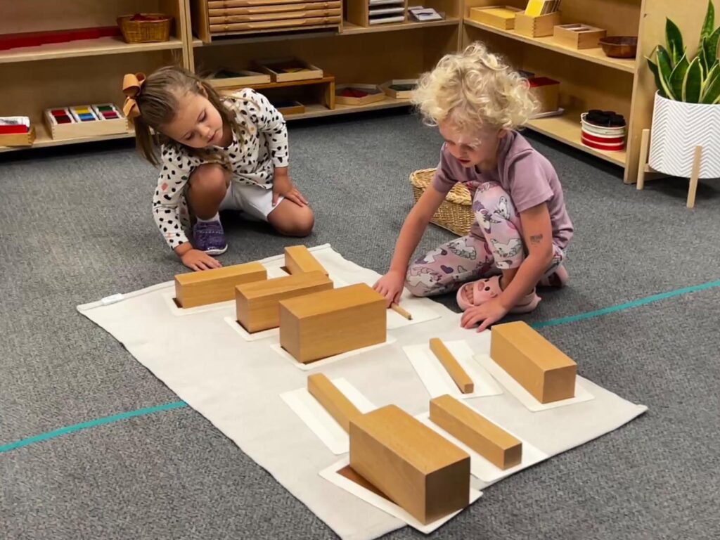 Students at a Montessori school in Fort Wayne, IN working with brown stairs