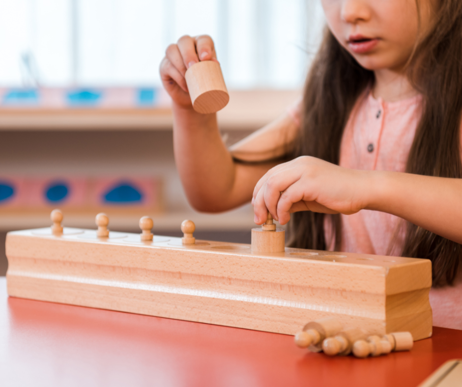child using knobbed cylinders in a Montessori classroom