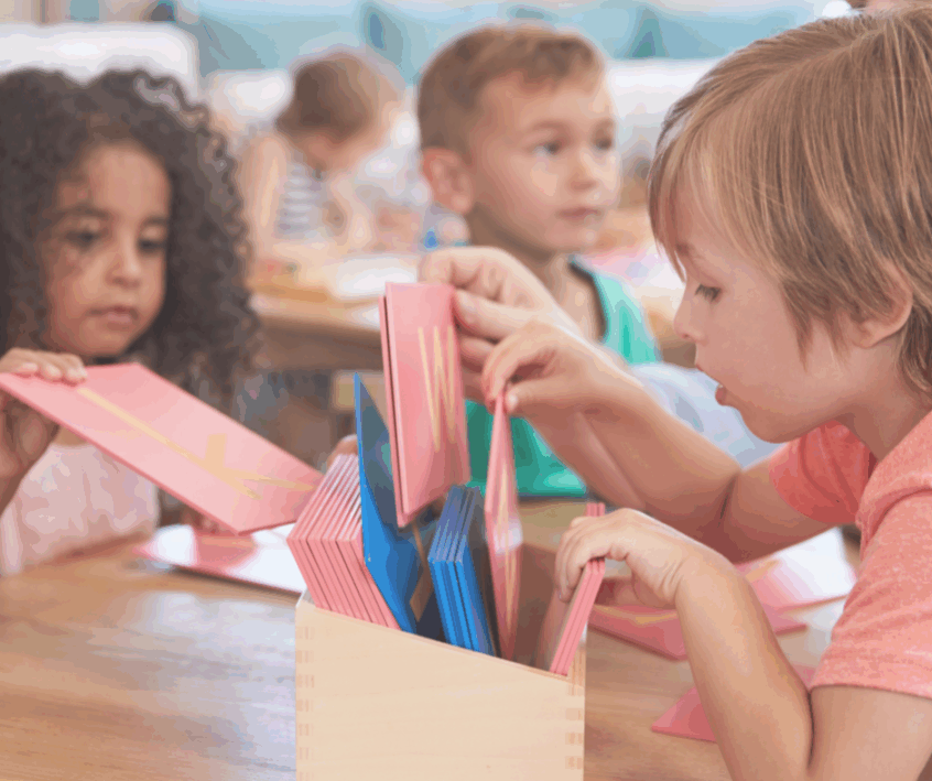 students working with sandpaper letters in a Montessori classroom