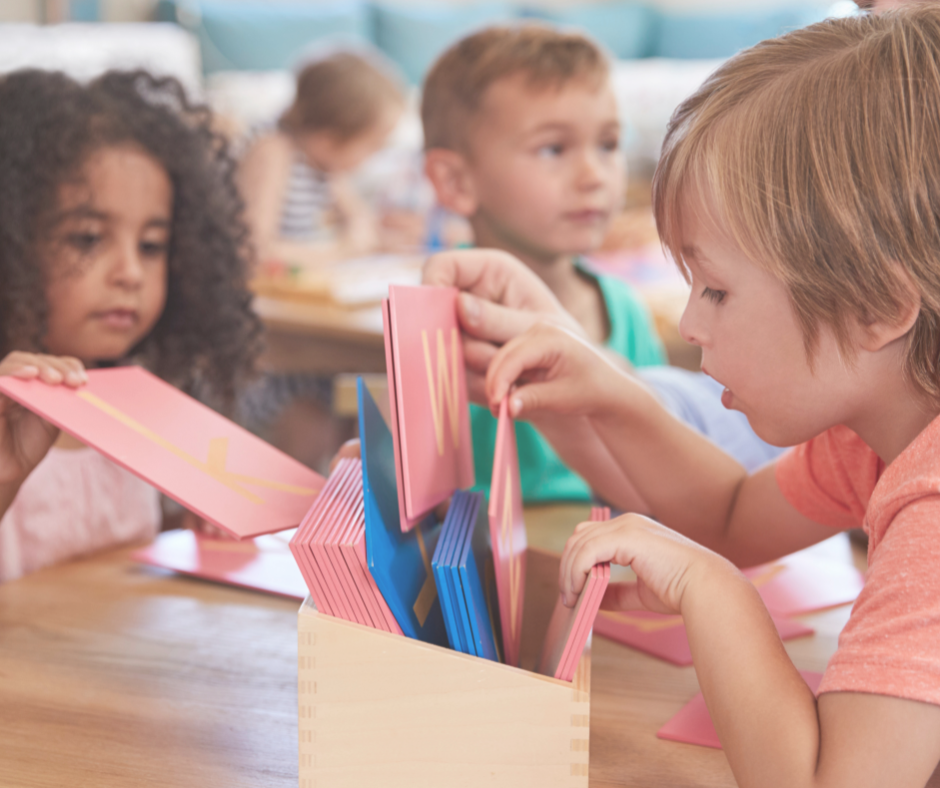students working with sandpaper letters in a Montessori classroom